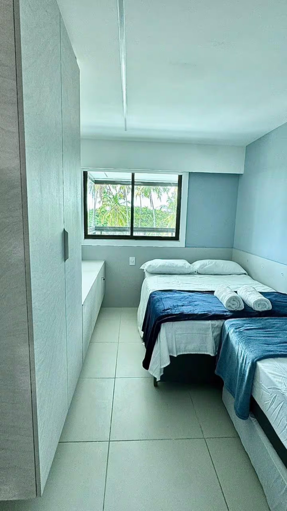 Suíte do apartamento 302D com cama de casal e roupa de cama azul.